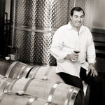 Winemaker, Mo Ayoub sat on wine barrel in his cellar